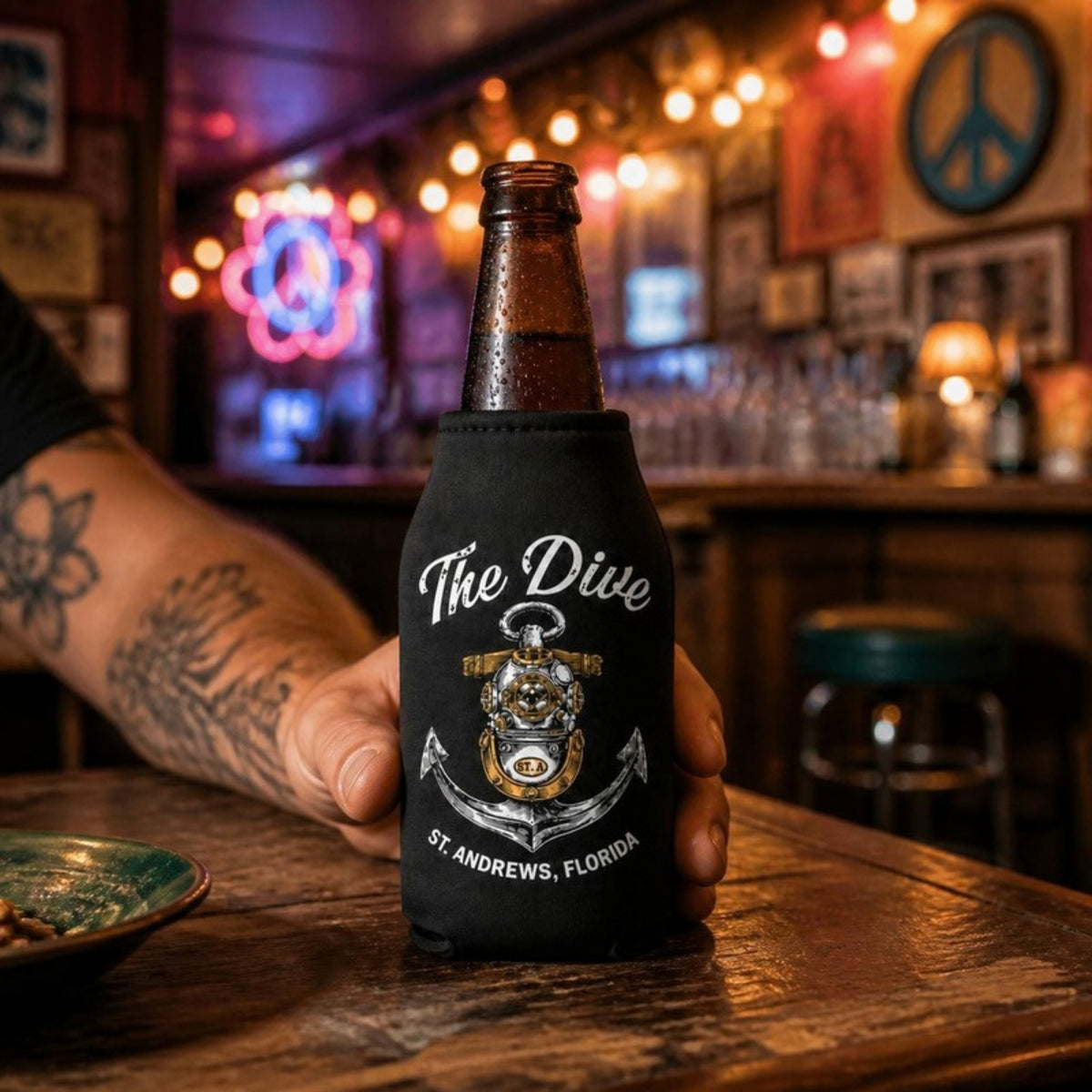 The Dive bottle koozie on a dive bar counter