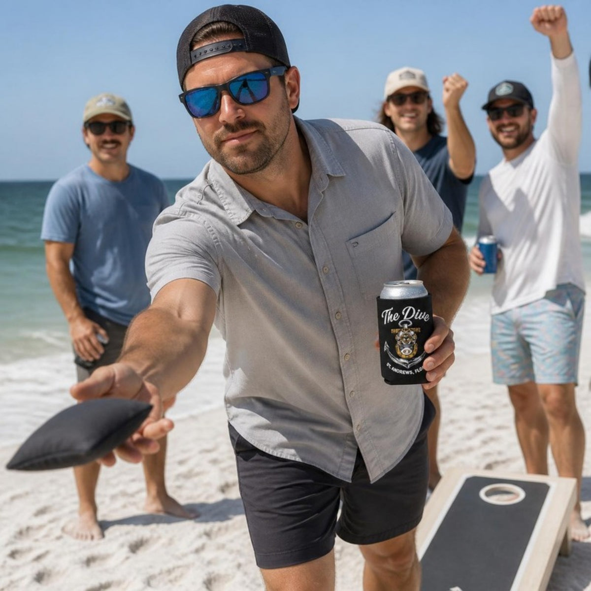Beach cornhole with The Dive can koozie