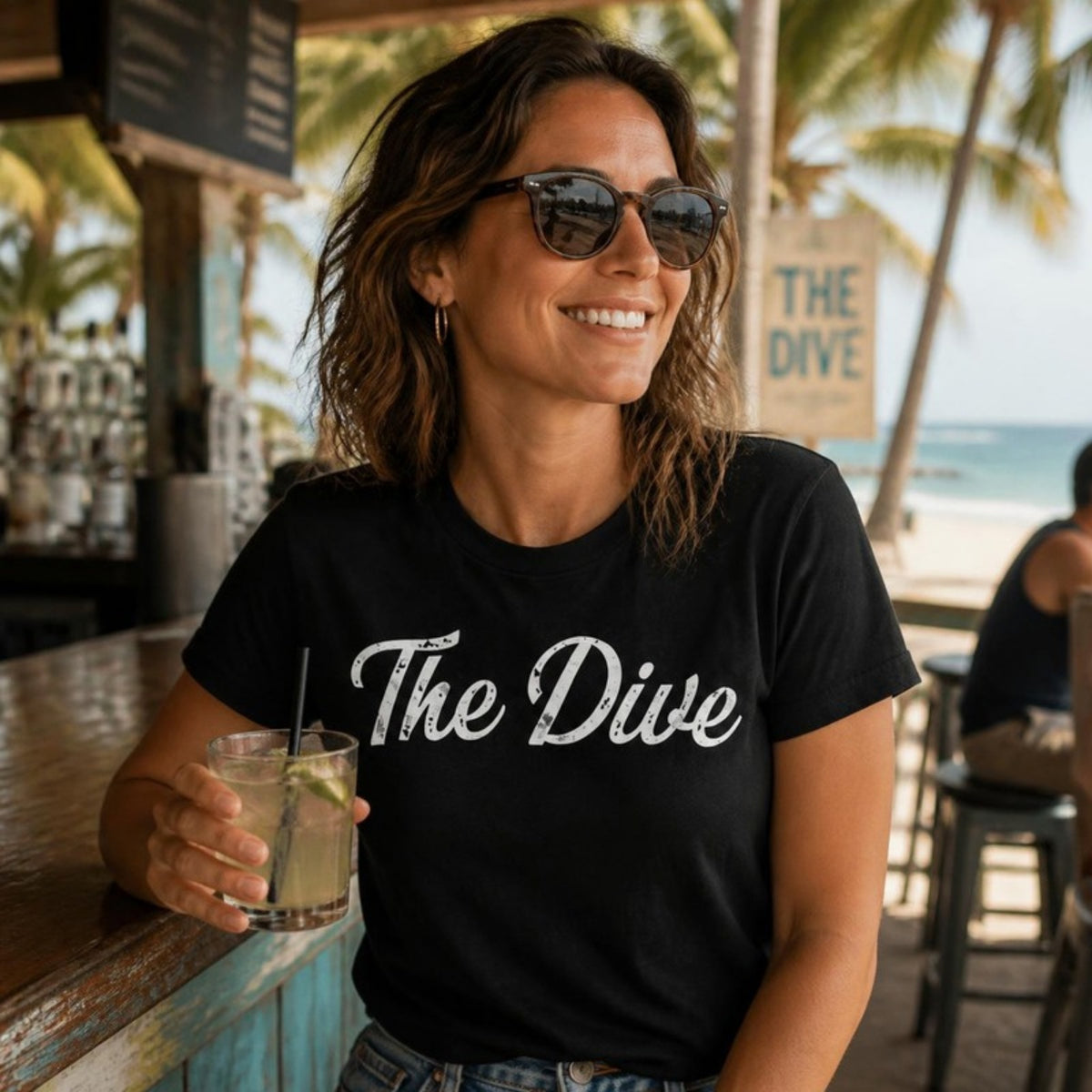 Woman in The Dive t-shirt at a beach bar