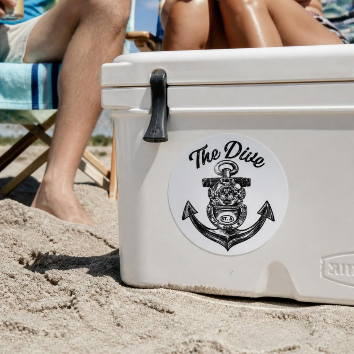 The Dive round sticker on a cooler at the beach